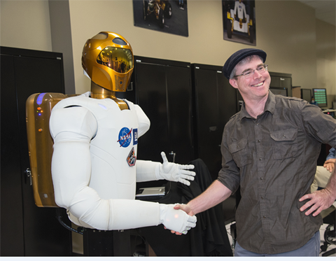 Weir gets up close and personal with Robonaut2. Image Credit NASA James Blair and Lauren Harnett