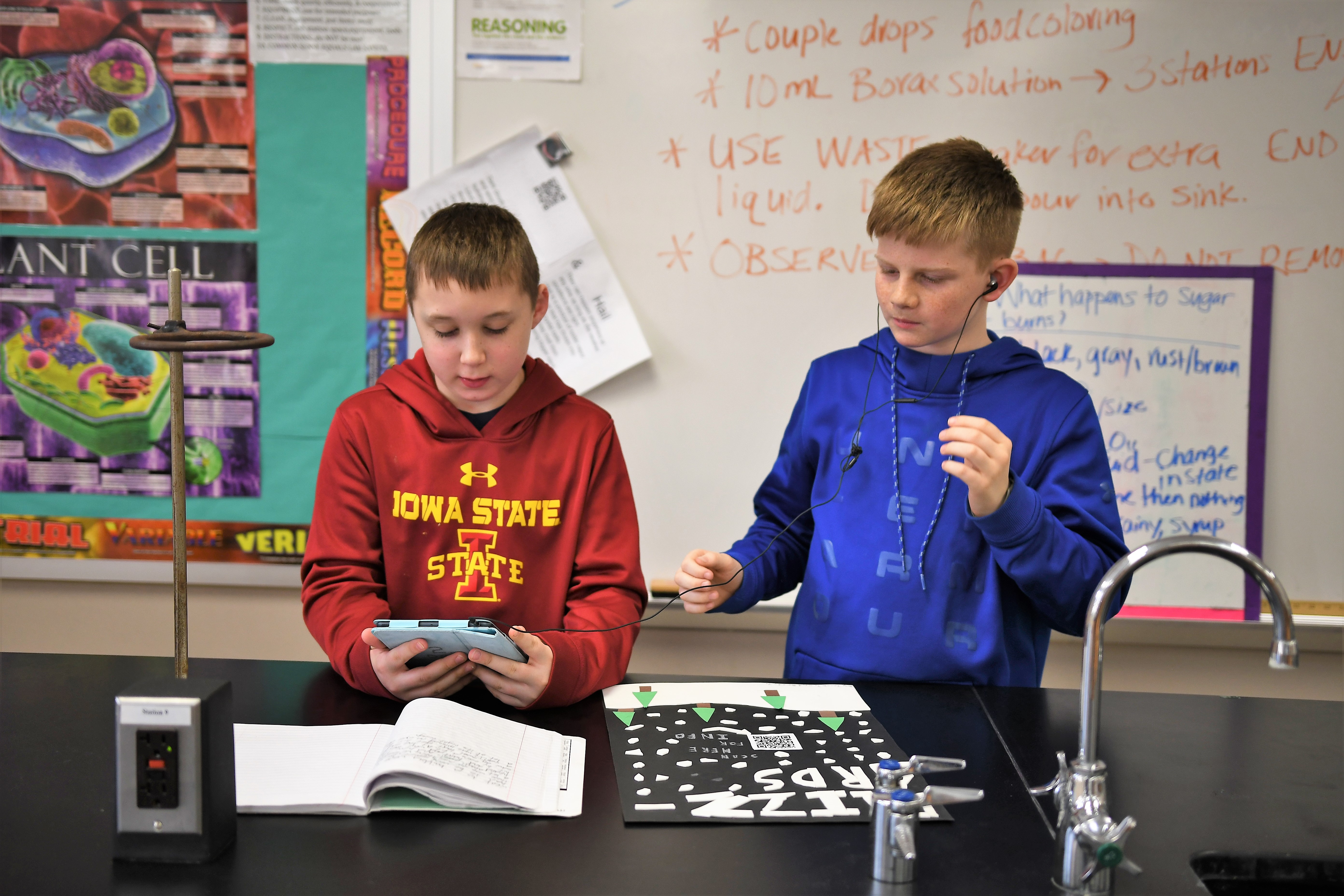 View of two sixth-graders reviewing a podcast on an iPad
