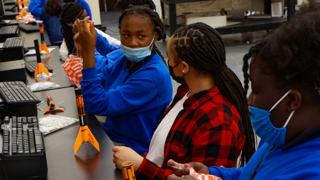 How is energy transferred to the gas particles during ignition?